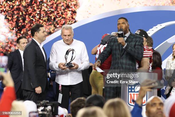 Hall of famer Joe Montana holds the George Halas Trophy as he talks with NFL commentator and former NFL player Michael Strahan after the San...