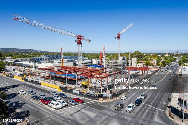 aerial view retail shopping mall construction site, two tower cranes & equipment in adelaide's eastern suburbs, busy main road intersection with traffic buildup. - shopping mall adelaide stock pictures, royalty-free photos & images