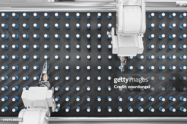 high angle view of robotic arms working on vaccine production on conveyor belt - healthcare and medicine from above stock pictures, royalty-free photos & images