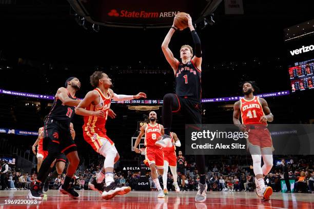 Gradey Dick of the Toronto Raptors scores over Trae Young of the Atlanta Hawks during the second half at State Farm Arena on January 28, 2024 in...