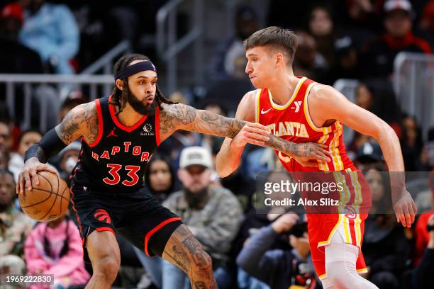 Gary Trent Jr. #33 of the Toronto Raptors works against Bogdan Bogdanovic of the Atlanta Hawks during the first half at State Farm Arena on January...