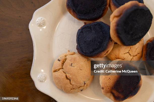 plate of burnt homemade chocolate chip cookies - burnt cookies stock-fotos und bilder