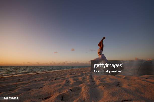 pilates exercises on the beach at sunset! - meeru island stock pictures, royalty-free photos & images