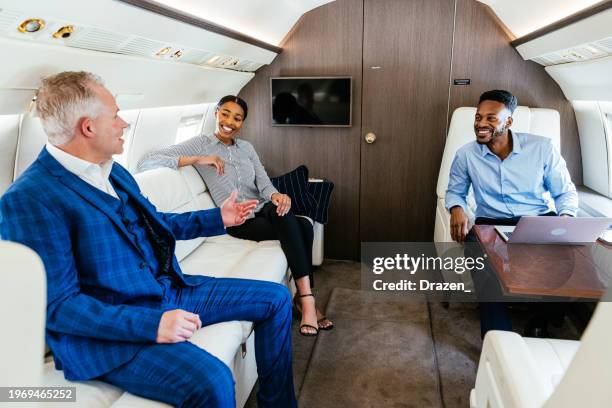 diverse business people flying in private jet. corporate people flying by private jet to the meeting and talking in relaxed atmosphere. - corporate jet stock pictures, royalty-free photos & images