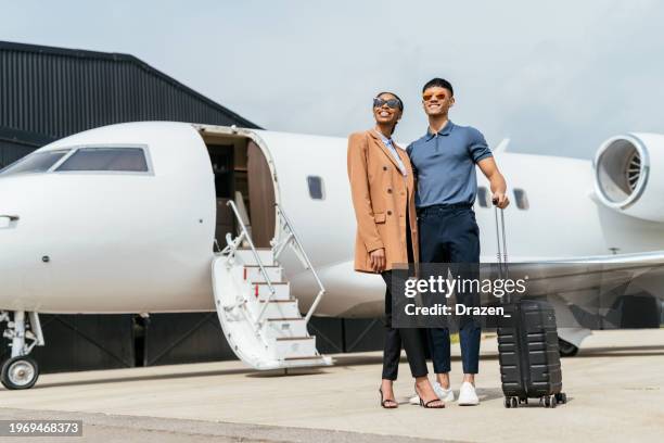 full length diverse passengers arriving to destination by private mid size jet. wealthy entrepreneurs using private airplane. - jet privé stockfoto's en -beelden