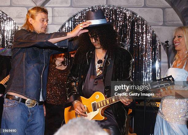 Kid Rock puts his hat on the head of Slash from Guns 'N' Roses as they perform on stage at the pre-Kentucky Derby Barnstable-Brown party May 2, 2003...