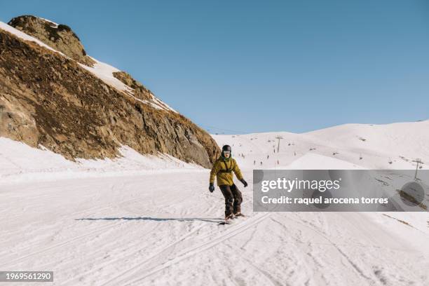 front view of an adult man snowboarding - nevada winter stock pictures, royalty-free photos & images