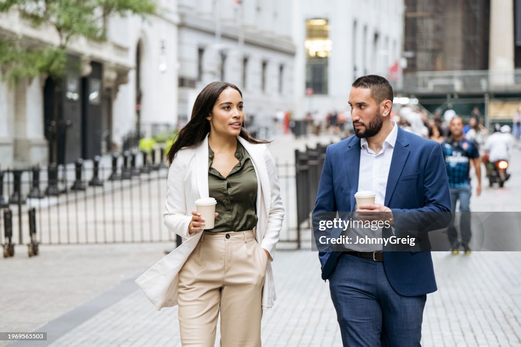 Manhattan business people walking and talking with coffee