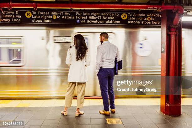 business associates waiting for nyc subway after work - new york city subway stock pictures, royalty-free photos & images