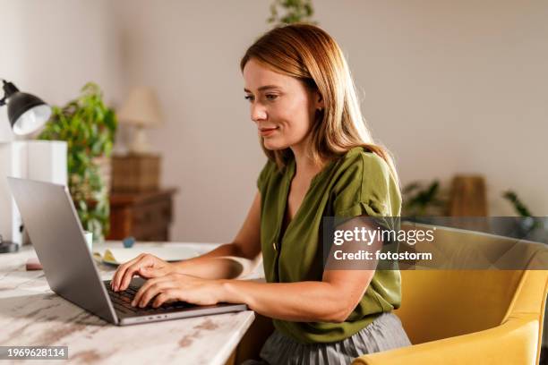 woman using laptop when working from home office - escritório em casa imagens e fotografias de stock