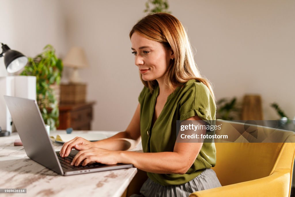 Woman using laptop when working from home office
