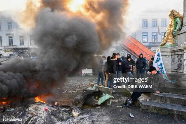 Man sits next to a statue during a farmer protest action in the European district in Brussels, organised by general farmers union ABS to demand...