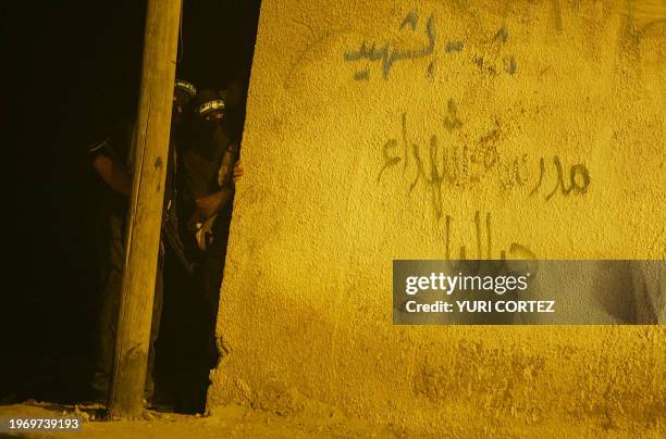 Palestinian masked gunmen take position early in the morning 16 August 2004 during an air raid by an Israeli Apache helicopter in the northern Gaza...