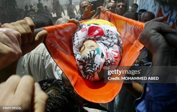 Palestinian mourners carry the body of 10-year-old Ali Abu Elba during his funeral in the northern town of Jabalia in the Gaza Strip 05 August 2004....