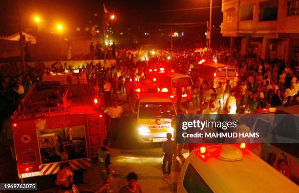 Palestinians gather at the scene after Israeli helicopter gunships fired rockets late 08 June 2004 at two workshops at the entrance to the Chatti...