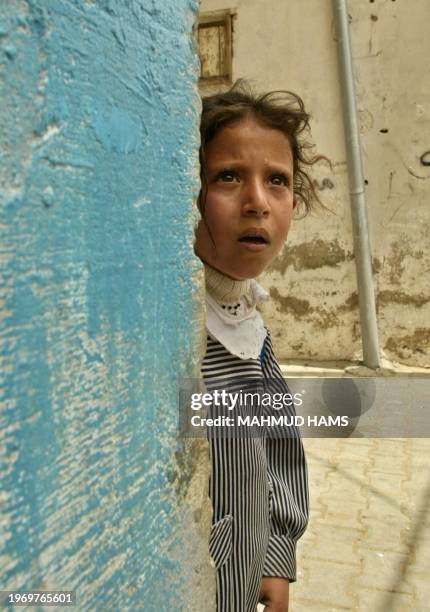 Palestinian schoolgirl looks at the funeral of Hamas militants Wael Nasser, Mohammed al-Sarsur and Madi al-Madi during in Gaza City 30 May 2004. The...