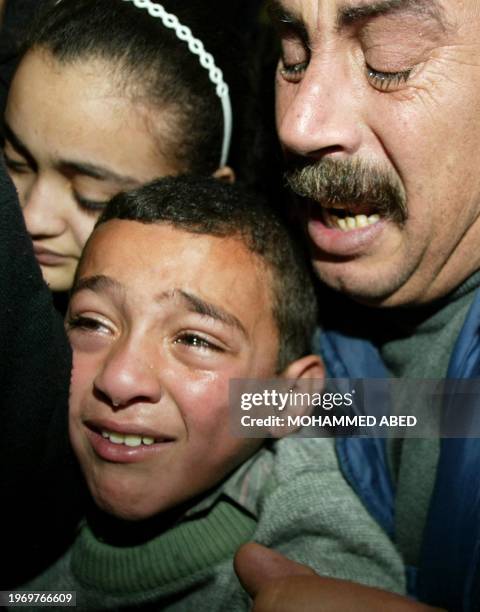 Brother and sister of 17-year-old Mohammed Heles mourn during Mohammed's funeral in Gaza City 12 February 2004. Heles was among fifteen Palestinians...