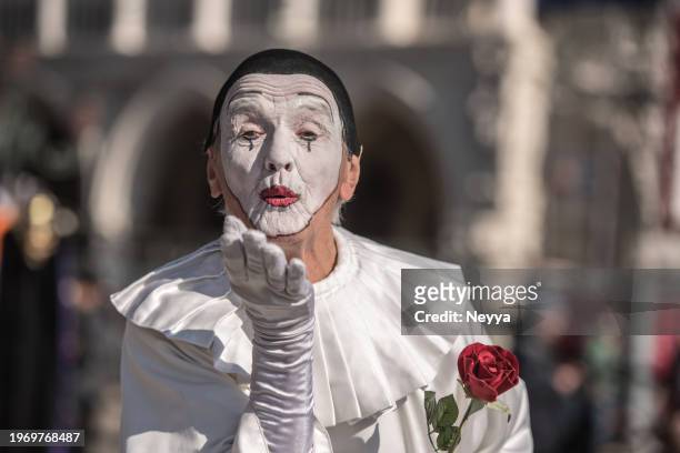 pierrot at venice carnival 2023 posing  with red rose in piazza san marco, venice, italy - pierrot clown stock pictures, royalty-free photos & images