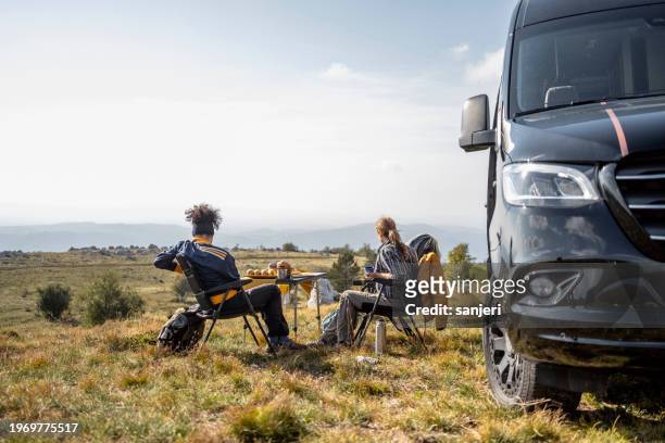 hikers camping with camping van - wonderlust stock-fotos und bilder