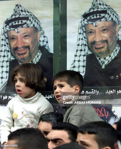 Palestinian children are seen in front of posters depicting the face of Palestinian leader Yasser Arafat during a protest in support of Palestinian...