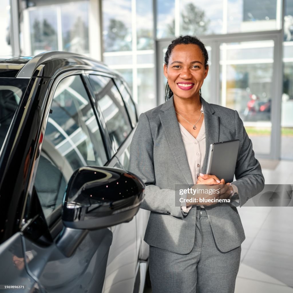 Portrait of a handsome female car saleswoman working in the showroom