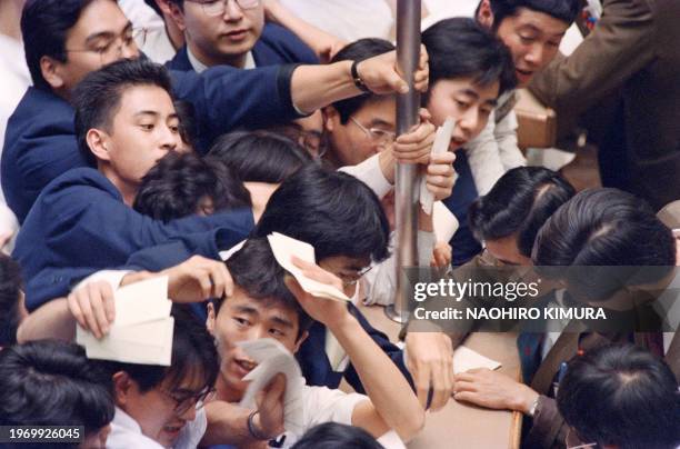 Traders struggle to rush to the dealing counter during the afternoon session of the Tokyo Stock Exchange on November 29, 1989. The Japanese...