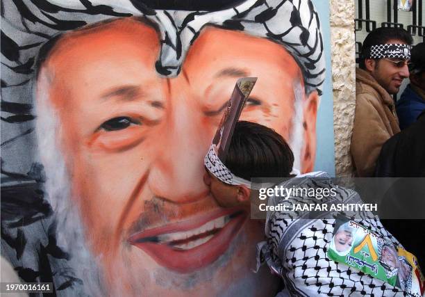 Palestinian student kisses a painting of his late leader Yasser Arafat during the internal elections to choose the students council of al-Najah...