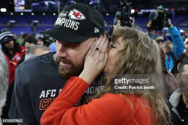 Travis Kelce of the Kansas City Chiefs celebrates with Taylor Swift as she whispers in his ear after a 17-10 victory against the Baltimore Ravens in...