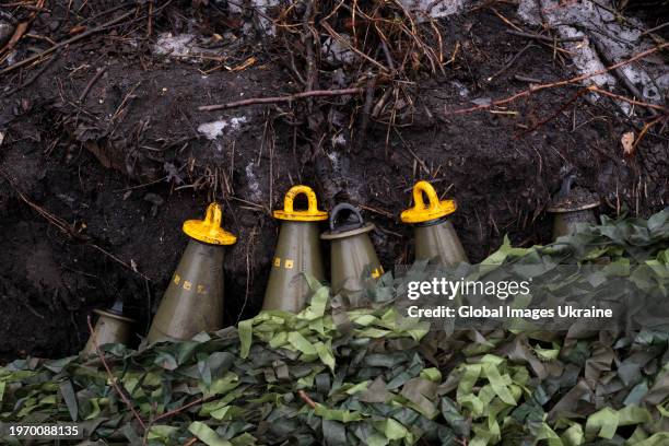 Camouflaged artillery rounds for M109 self-propelled howitzer lie with plugs, not ready for use, detonator must be installed before firing on...