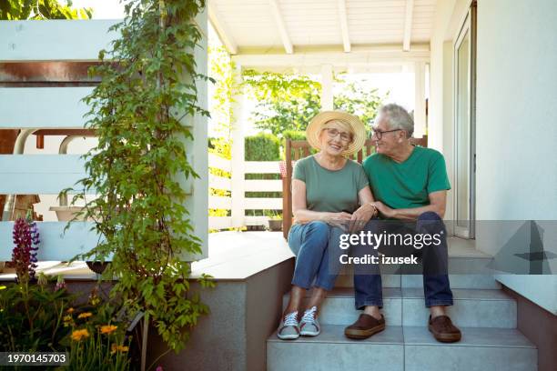 portrait of senior couple outside house - happy couple front porch stock pictures, royalty-free photos & images