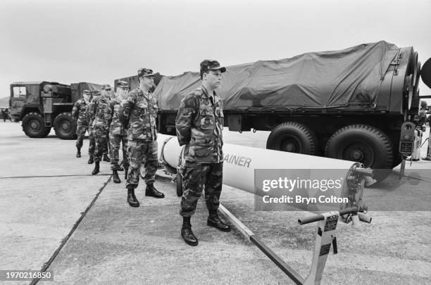 Troops from the United States Air Force display a dummy cruise missile alongside a launch vehicle at Greenham Common air base ahead of a visit by...