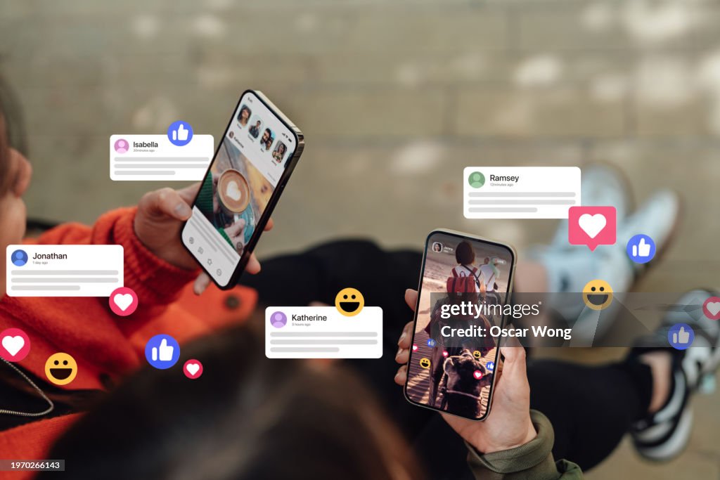 Closeup of two friends commenting and giving likes on social media platform via smartphone