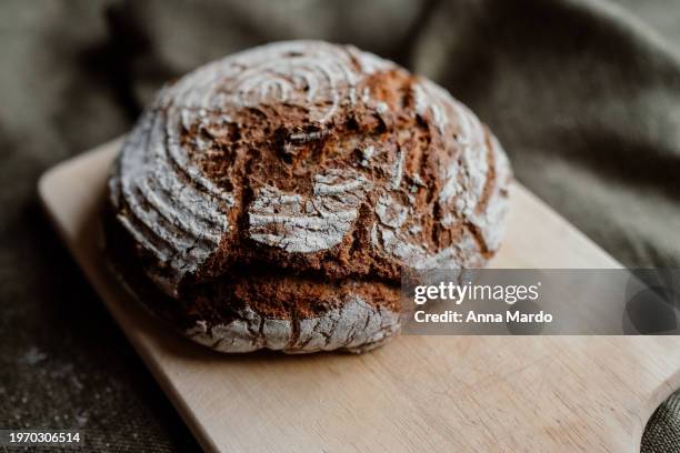 homemade fresh sourdough bread made of rye flower on a wooden cutting board - miche de pain photos et images de collection