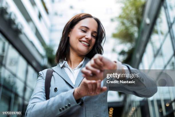 young businesswoman monitoring watch - smartwatch stockfoto's en -beelden