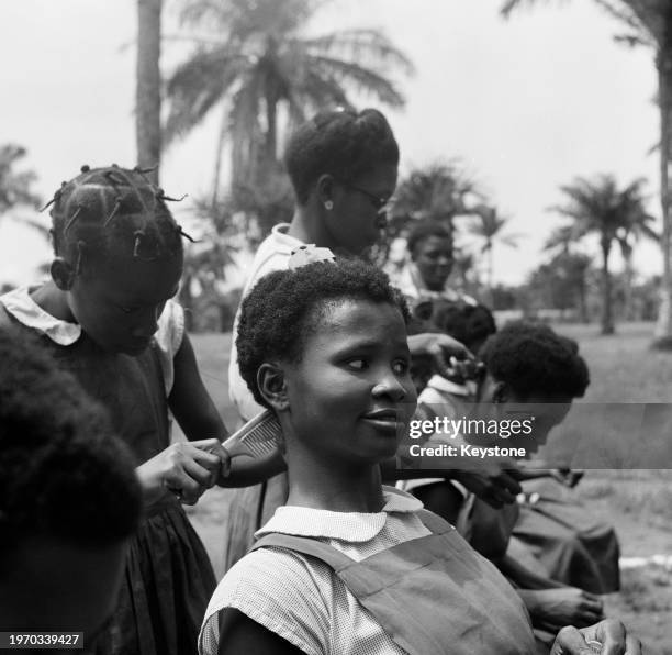 Pupils styling each other's hair at Queen's College, a girls' boarding school in Lagos, Nigeria, June 1959. The school moved to its new premises in...