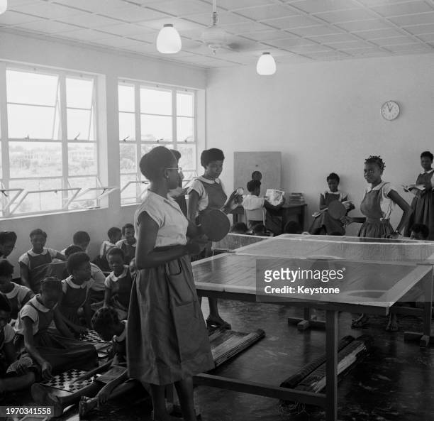 Pupils playing table tennis and draughts in the junior common room of Queen's College, a girls' boarding school in Lagos, Nigeria, June 1959. The...