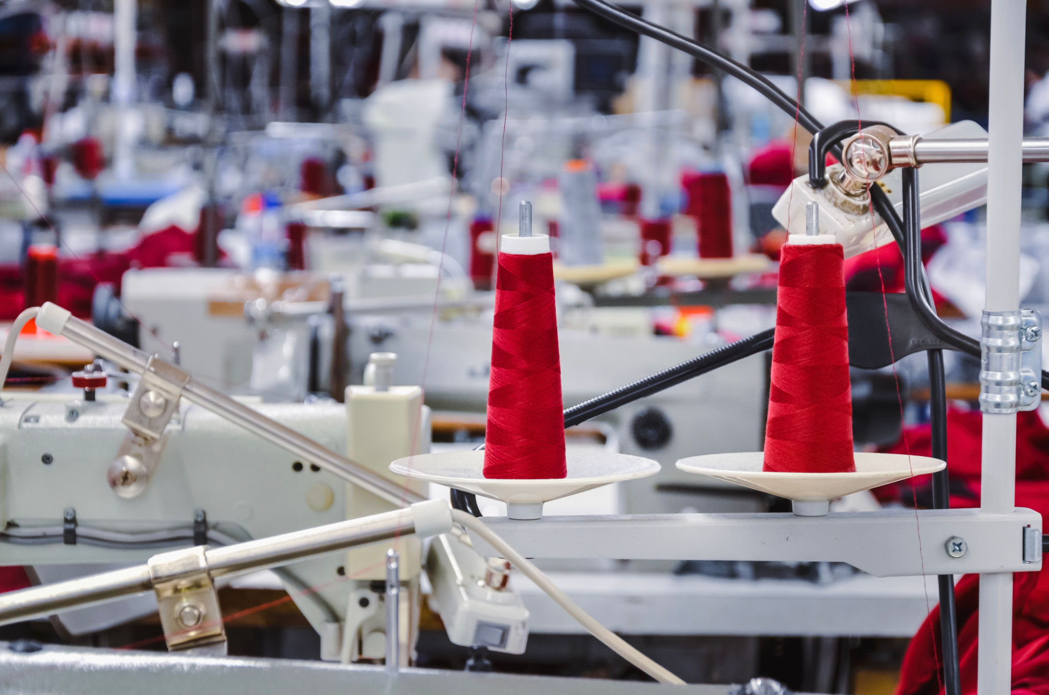 Red threads on a sawing machine in the factory Red threads on a sawing machine in the factory