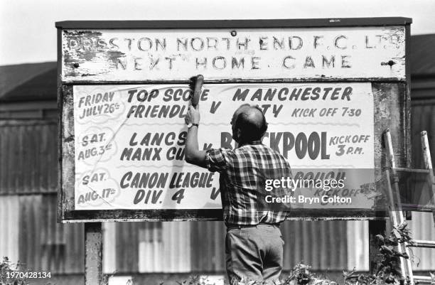 Peter McCallion, the groundsman for Preston North End football club, pastes up the fixture list outside the Deepdale Stadium in Preston, Lancashire,...