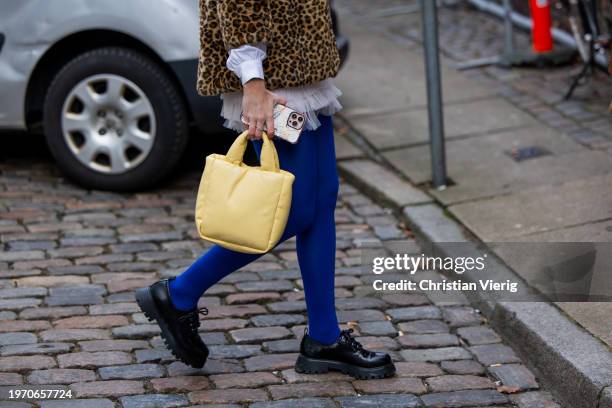 Guest wears animal leopard print jacket, ruffled blouse, yellow bag, blue tights outside Nicklas Skovgaard during the Copenhagen Fashion Week AW24 on...