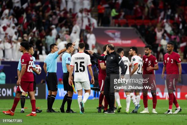 Players and team staff of Palestine argue with referee Ma Ning after the AFC Asian Cup Round of 16 match between Qatar and Palestine at Al Bayt...