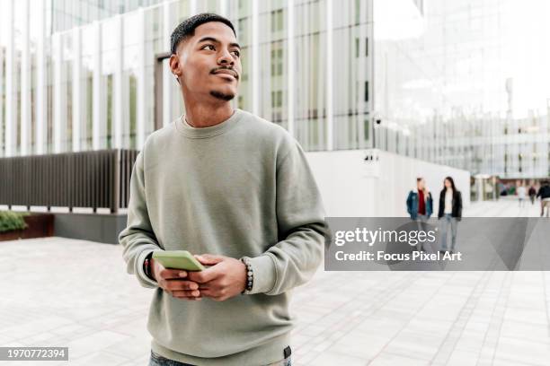 cool african american student using phone distracted in the campus - college student portrait stock pictures, royalty-free photos & images