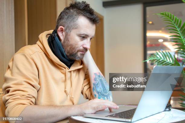 a man working with laptop in cafe - hybrid learning stock pictures, royalty-free photos & images