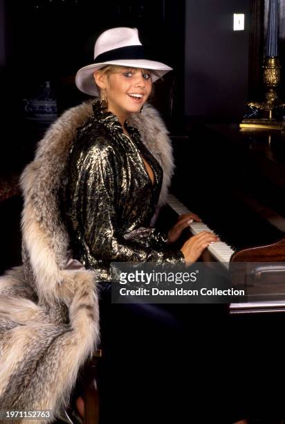 British actress Olivia d'Abo poses for a portrait playing her piano in Los Angeles, California, circa 1984.