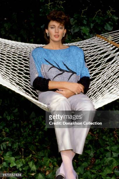English actress Sarah Douglas poses for a portrait sitting in her hammock in Los Angeles, California, circa 1985.