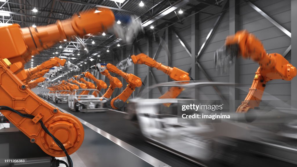 Industrial Robots In Motion At The Automatic Car Manufacturing Factory Assembly Line