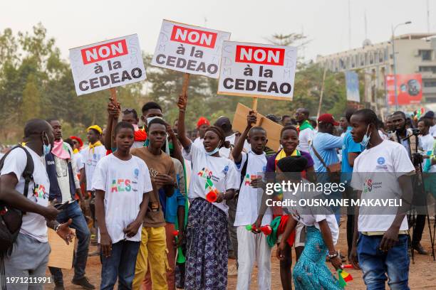 Supporter of the Alliance Of Sahel States hold placards reading 'no to ECOWAS' during a rally to celebrate Mali, Burkina Faso and Niger leaving the...