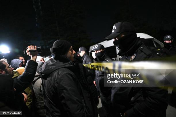 Relatives of hostages gather as Turkish anti-riot police officers block the street where a plant owned by US giant Procter & Gamble is located at...