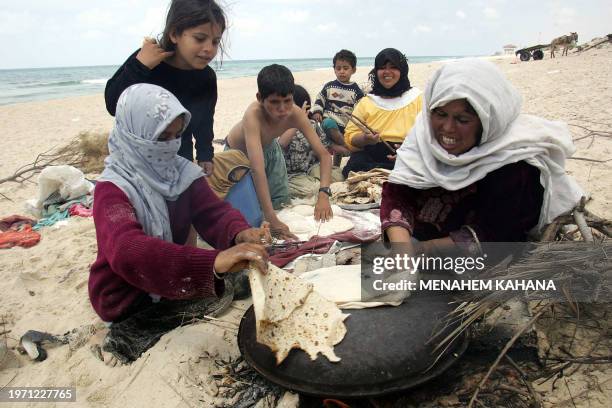 Palestinian woman bakes bread on the beach in Mawasi, a 12 kilometer stretch of agricultural land inhabited by Palestinians and surrounded by the...