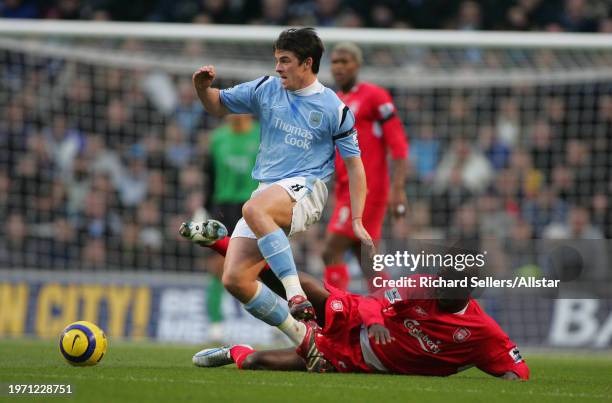 November 26: Joey Barton of Manchester City and Momo Sissoko of Liverpool challenge during the Premier League match between Manchester City and...