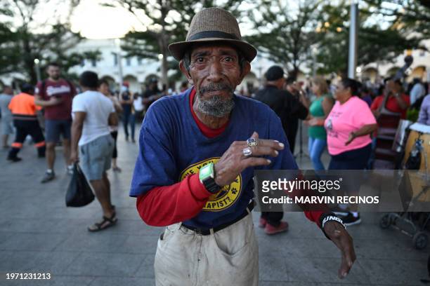 People dance while musicians perform in the street at the San Salvador Historical Center in San Salvador on February 1, 2024.